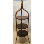 An Edwardian inlaid mahogany circular three-tier cake stand on shaped supports