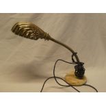 An old brass scallop-shaped adjustable desk lamp with ceramic base
