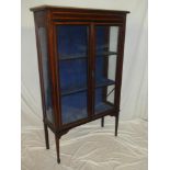 A late Victorian inlaid mahogany display cabinet with fabric lined shelves enclosed by two glazed