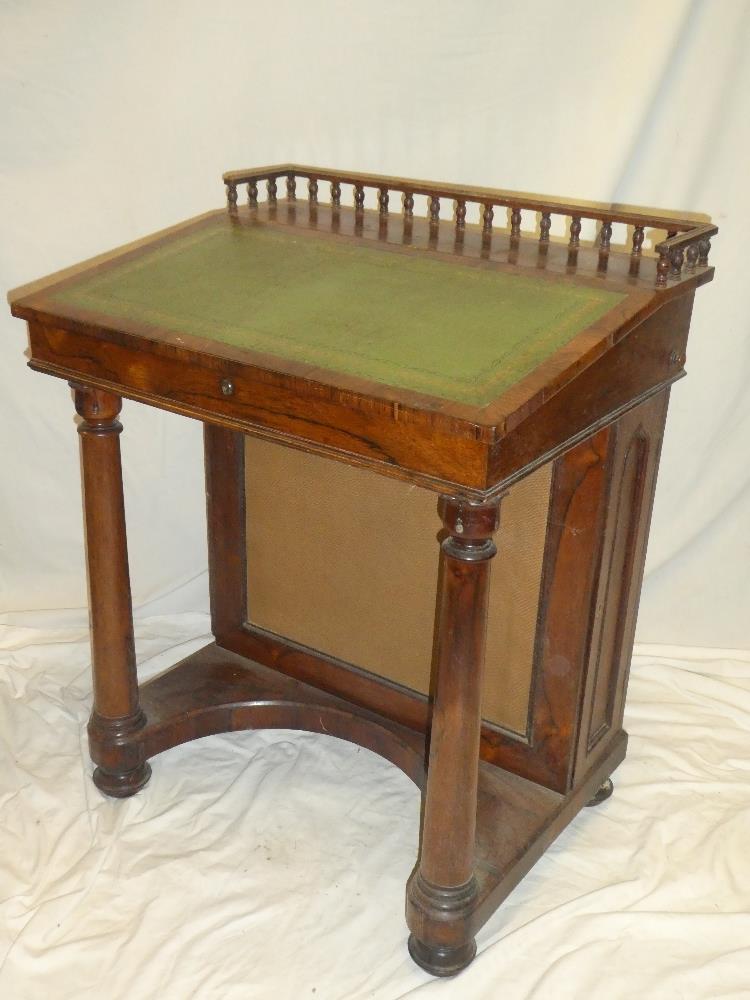A Victorian rosewood Davenport desk with pigeon holes enclosed by a hinged sloping writing surface,
