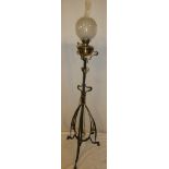 An Art Nouveau painted iron adjustable oil lamp standard supporting a brass oil lamp with etched