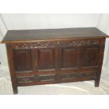 An 18th century carved oak rectangular mule chest with panelled front and two base drawers on block