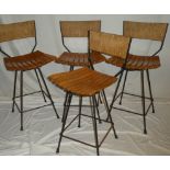 A set of four 1960's swivel bar stools by Arthur Umanoff with polished slatted seats and rattan