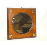 A bevelled circular wall mirror in brass mounted oak frame,