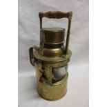 An old brass ship's cylindrical hand held signalling lamp with turned wood handle (lens damaged)