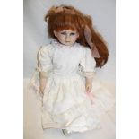 A porcelain headed child's doll marked "9429A" with cloth and composition body 21" long