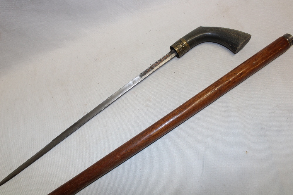 An Eastern sword stick with 14" single edged blade and horn handle in teak walking stick mount