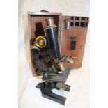 A brass and painted metal monocular microscope by R & J Beck of London in fitted case with