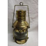 A brass ship's anchor lamp with ribbed glass lens and oil fitment 14" high