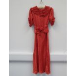 A late 1930's early 40's burnt orange silk full length evening dress with ruching detail at