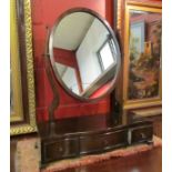 A George III style mahogany dressing chest oval mirror over a three drawer serpentine front base on