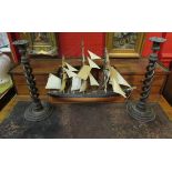 A pair of barley twist candlesticks and a model boat