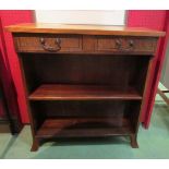 A George III style cross banded mahogany bookshelf with two drawers over out swept bracket feet,