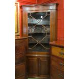 A 19th Century mahogany full height barrel back corner cabinet the astragal glazed single door with