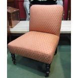 A late Victorian upholstered ebonised armchair on turned legs & castors