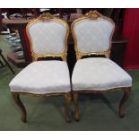 A pair of 19th Century style French gilt chairs with carved decoration