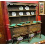 An oak dresser with plate rack top with shaped frieze,