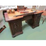Circa 1900 an oak break front twin pedestal desk with leather writing surface the central drawer