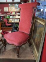 A circa 1840 carved walnut bedroom chair with pink upholstery on scroll feet and brass castors