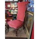 A circa 1840 carved walnut bedroom chair with pink upholstery on scroll feet and brass castors