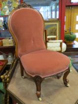A circa 1850 carved walnut bedroom chair with pink upholstery on scroll feet and white ceramic