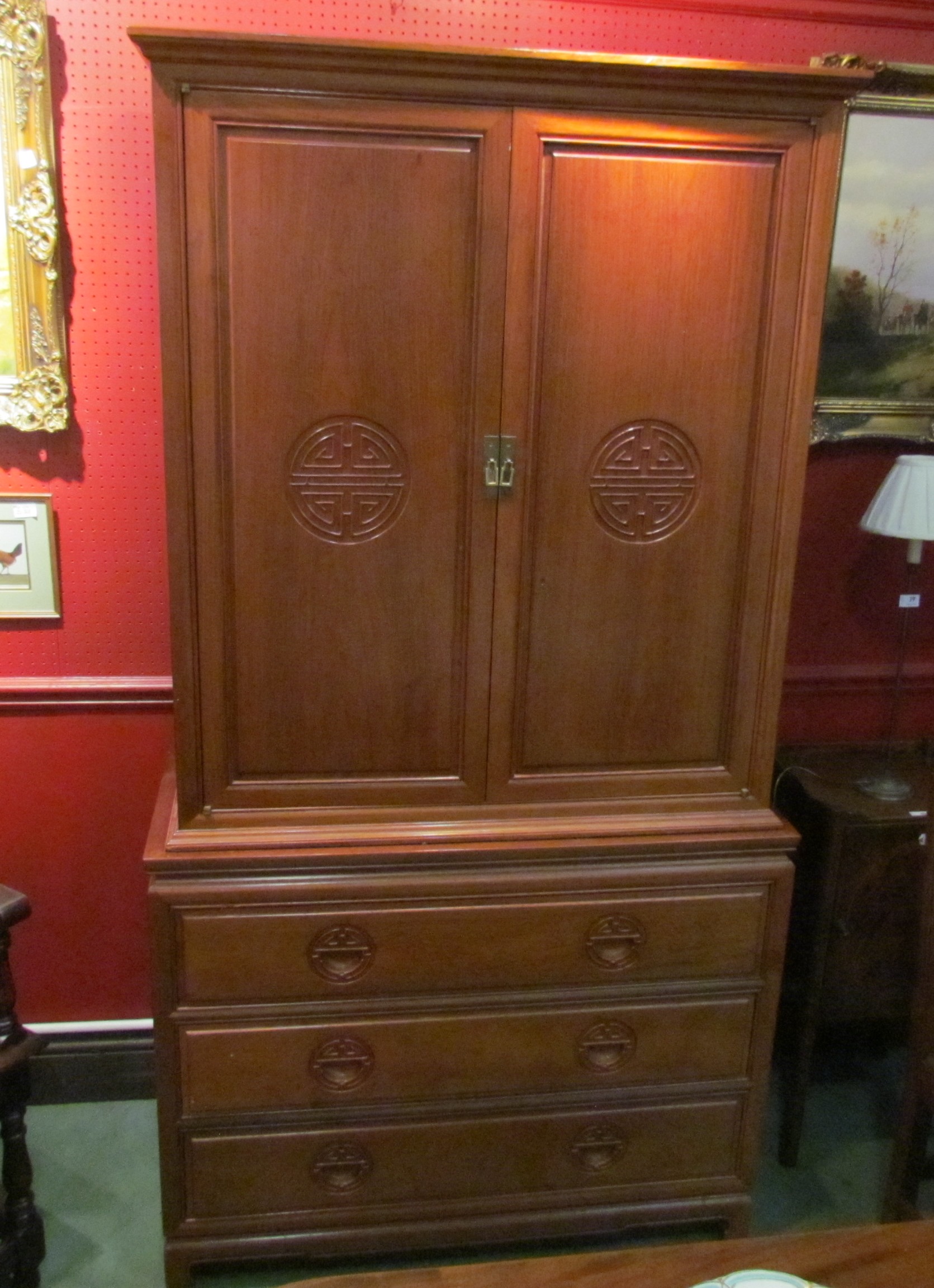 A Chinese cabinet the two doors opening to reveal eight small drawers and four open section above a