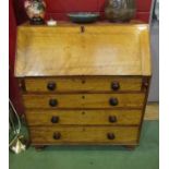 A Victorian four drawer bureau, drop-flap revealing fitted interior, turned feet,