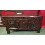A 17th Century oak coffer the hinged lid over a three panel carved front on stile feet,