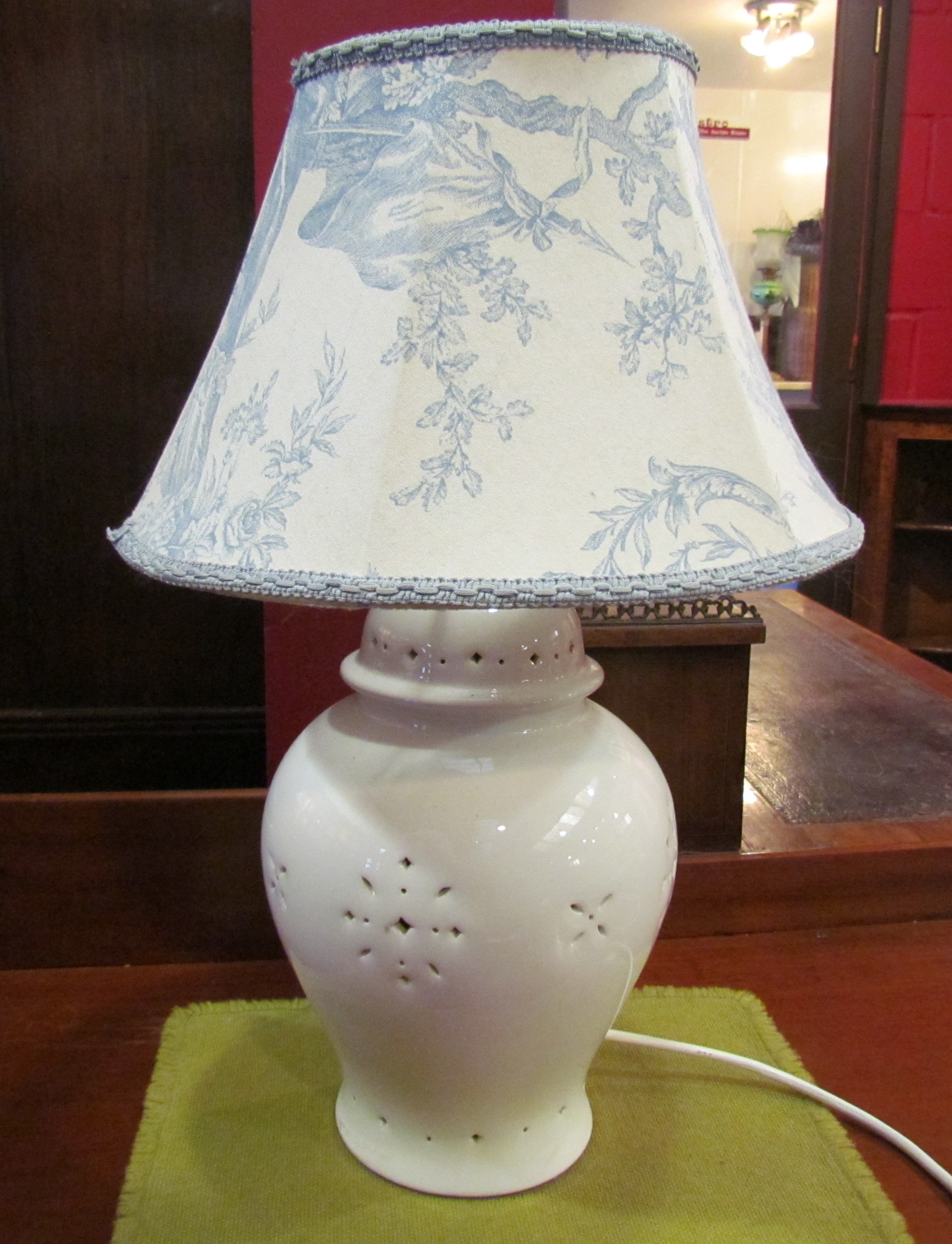 A cream table lamp with pierced detail