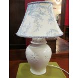 A cream table lamp with pierced detail