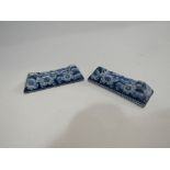 A pair of blue and white transfer pottery knife rests