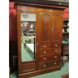 An Edwardian compactum wardrobe with single mirrored door and two door hanging space over two over