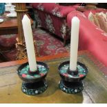 A pair of cast iron candle holders with painted strawberry and vine design