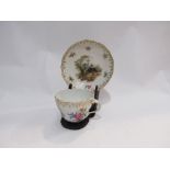 A Meissen cup and saucer on display stand, wildlife and hunting scenes,