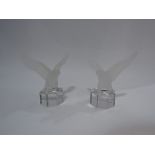 A pair of frosted glass decorative figures of eagles, two glass dishes,