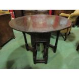 A 19th Century carved oak drop leaf table on carved legs with rose.