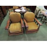 A pair of early 20th Century oak armchairs with brown leather supports and back, stud work,