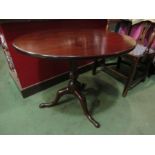A George III mahogany circular tilt top wine table on a turned column and tripod base 75cm in