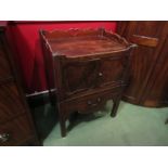 A Georgian mahogany nightstand with fret work galleried back and sides over two door cupboard with