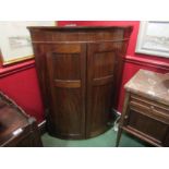 A George III flame mahogany bow fronted wall hanging corner cabinet,