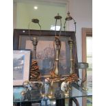 Three brass Pullman style carriage table lamps raised on shaped tripod legs with a hole to one foot,