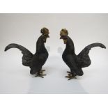 A pair of bronzed cockerel figures with brass detailing,