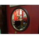 An oval bevel edged mahogany framed mirror,
