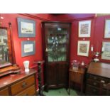 A George III line inlaid mahogany corner cabinet the Astragal glazed single door over a two door