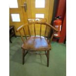 A circa 1900 elm and ash captain's elbow chair on ring turned supports and legs joined by