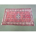 A pink ground machine woven Eastern rug with central lozenge,