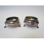 A pair of Victorian silver salts with embossed design London 1860, marks rubbed, feet misshapen,