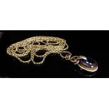 A Victorian oval amethyst pendant, unmarked, hung on a gold guard chain, 136cm long, 29.