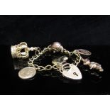 A 9ct gold charm bracelet hung with various charms including Crown, boot, dog soldier etc, 21.