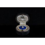 A memorial brooch with blue enamel front centrally set with single pearl framed by seed pearls,
